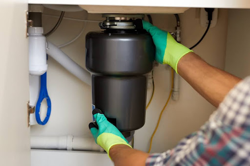 Homeowner working on garbage disposal unit.
