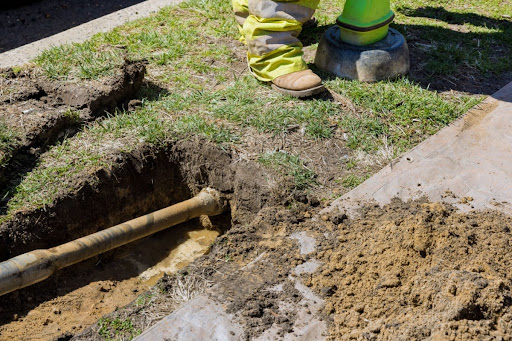 Plumber digging trench for sewer repairs.