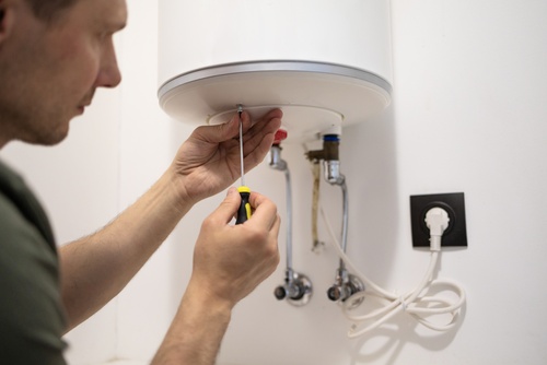 A plumber repairs a tankless water heater